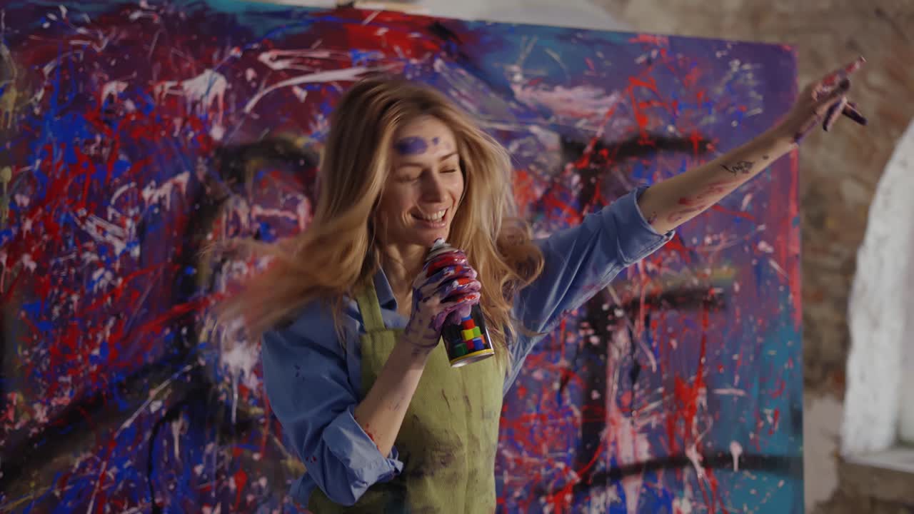 Kvinde danser i kunststudie i slowmotion, lader som om hun synger til en spraydåse