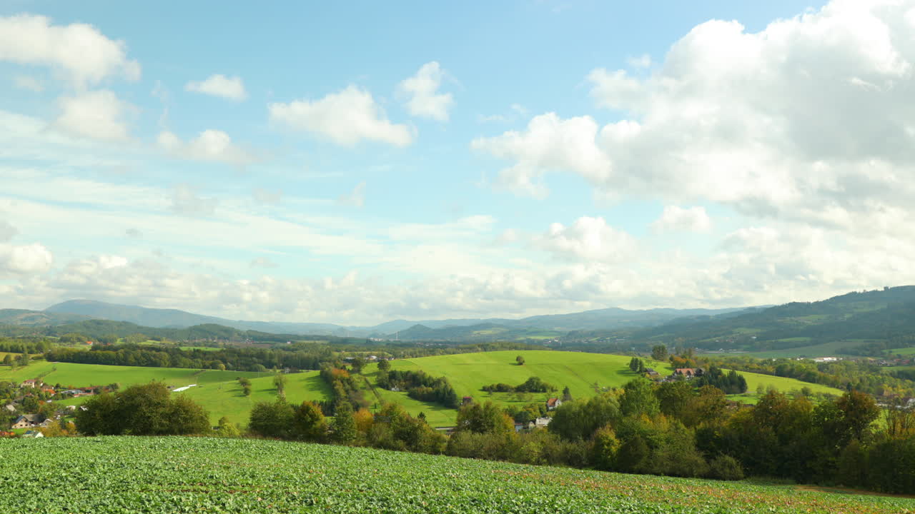 움직이는 구름과 그 그림자는 4k 60fps로 캡처된 화창한 날 높은 언덕의 배경인 베스키드 국립공원 지역의 풍경과 들판 위의 땅에 반사됩니다.
