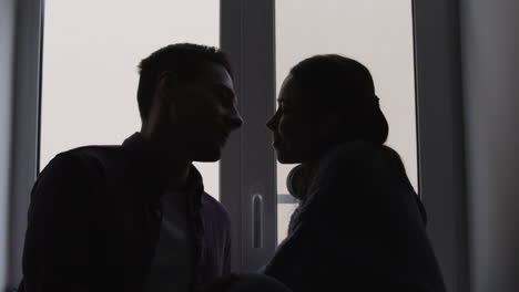 couple kissing by the window