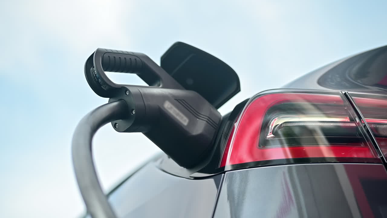 Bir şarj istasyonunda elektrikli bir arabaya takılı şarj cihazının yakın çekim görüntüsü
