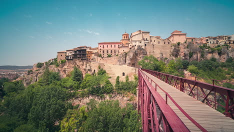 cuenca iconic landmark people crossing bridge and casas colgadas houses in a blue sky summer day