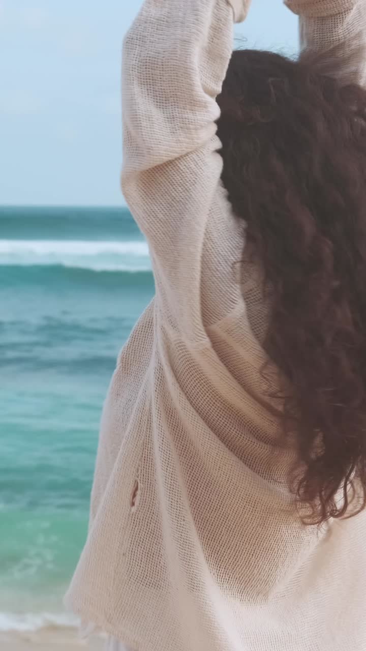Embracing freedom by the ocean waves on a sunny beach day