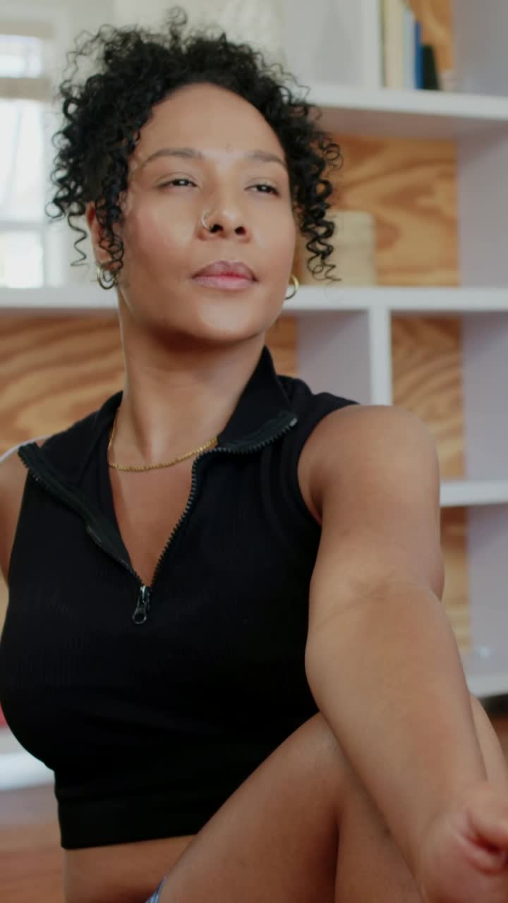 Woman in crop top starting seated twist crossing leg, twisting torso, turning head left for health