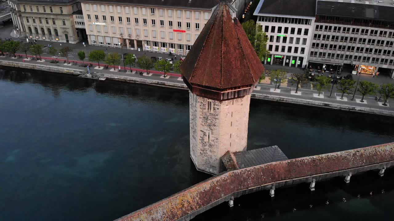 vista aérea del puente kapellbrücke en lucerna, suiza girando alrededor de la torre del puente para revelar el histórico altstadt