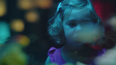 little girl looking at fish in aquarium curious child watching colorful sea life swimming in tank learning about marine animals in underwater ecosystem inquisitive kid at oceanarium