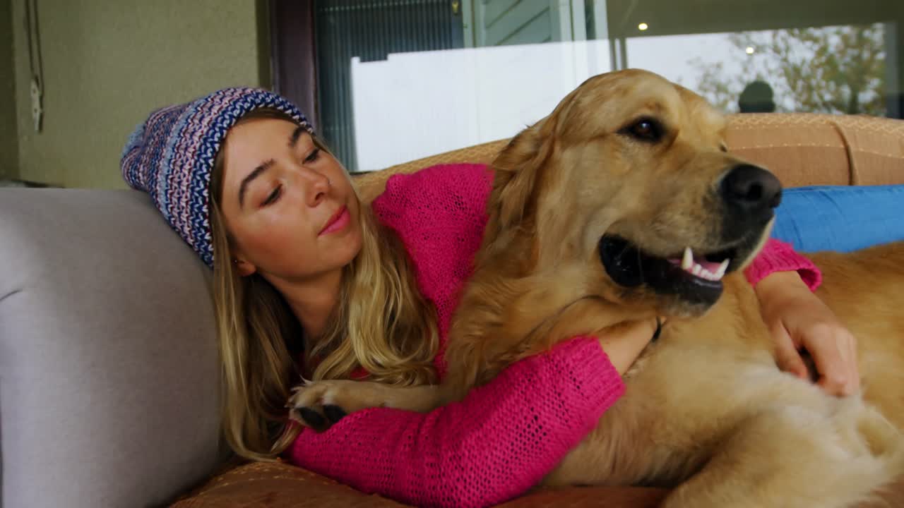 집 에서 소파 에 있는 개 를 키스 하는 여자 4k