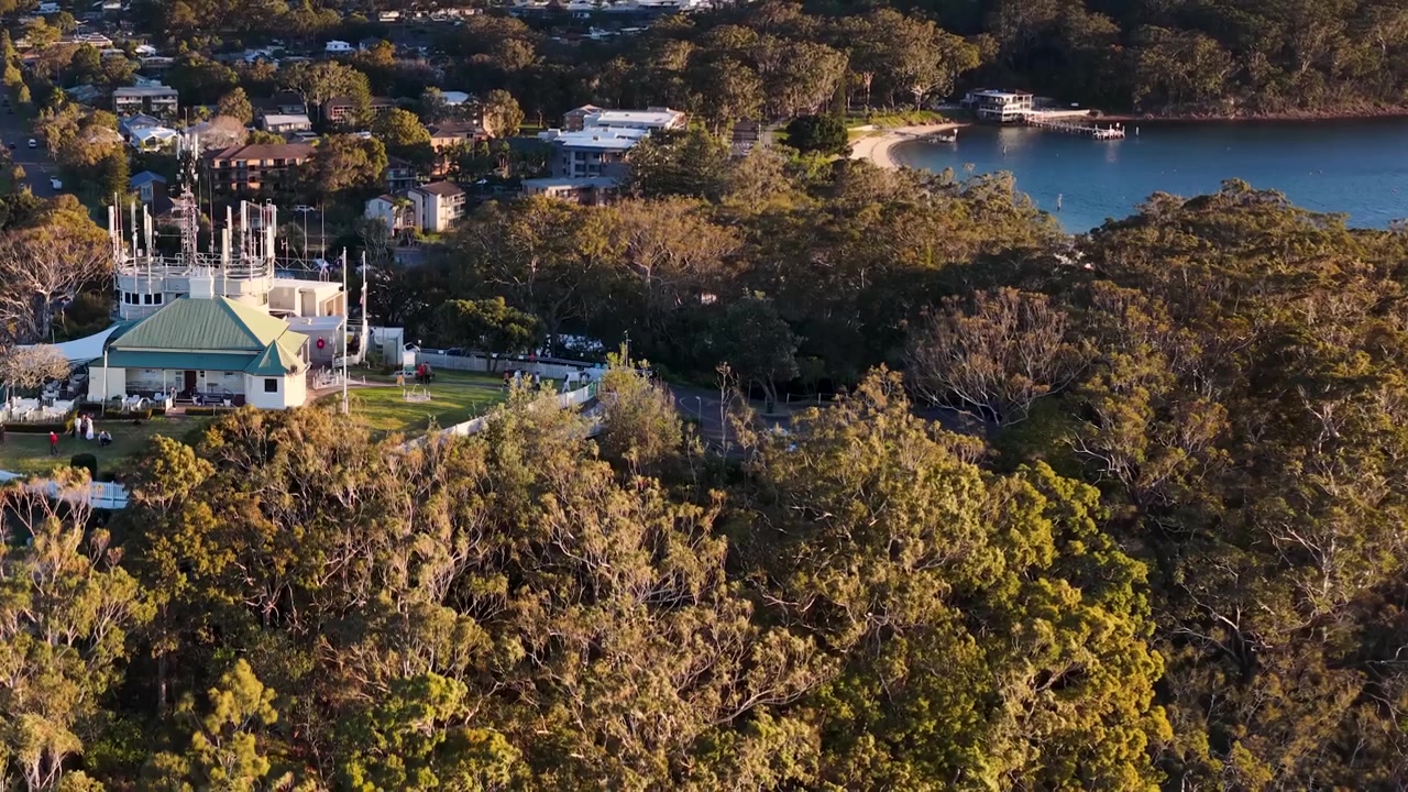 Ripresa aerea con drone della costa di Nelson Bay, foreste lussureggianti ed edifici residenziali in Australia