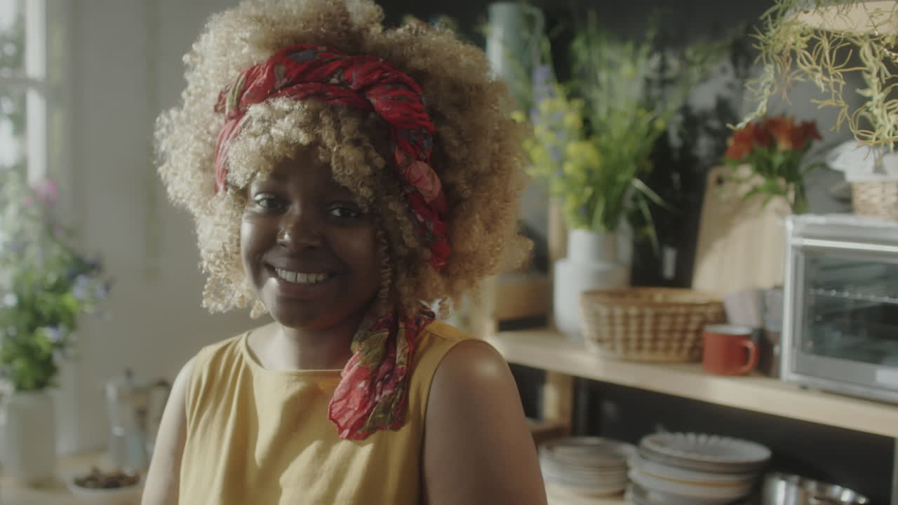 Portret van vrolijke Afro-Amerikaanse vrouw in keuken