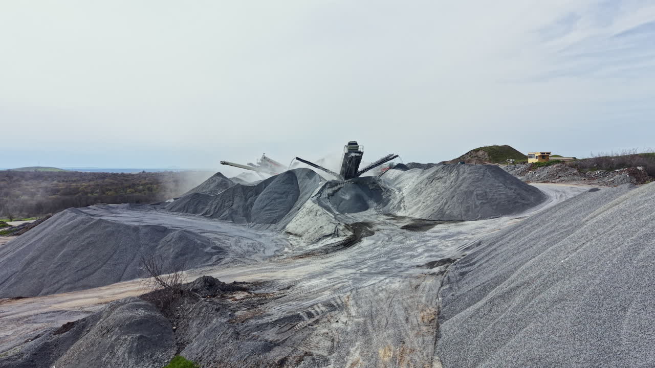 Pekerja granit mengoperasikan mesin untuk mengolah batu di tambang granit di lokasi terpencil pada hari berawan