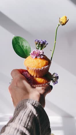 handheld decorated cupcakes with flowers