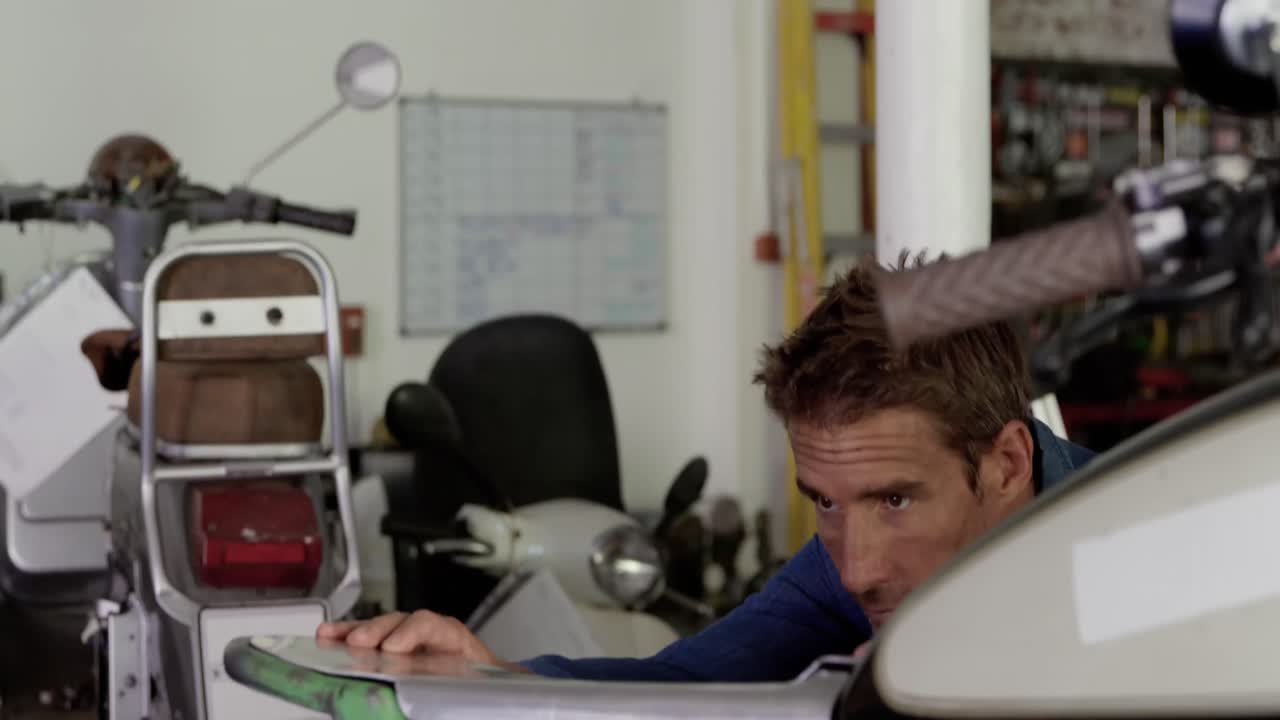 수리 공장에서 오토바이를 수리하는 남성 기계공 4k