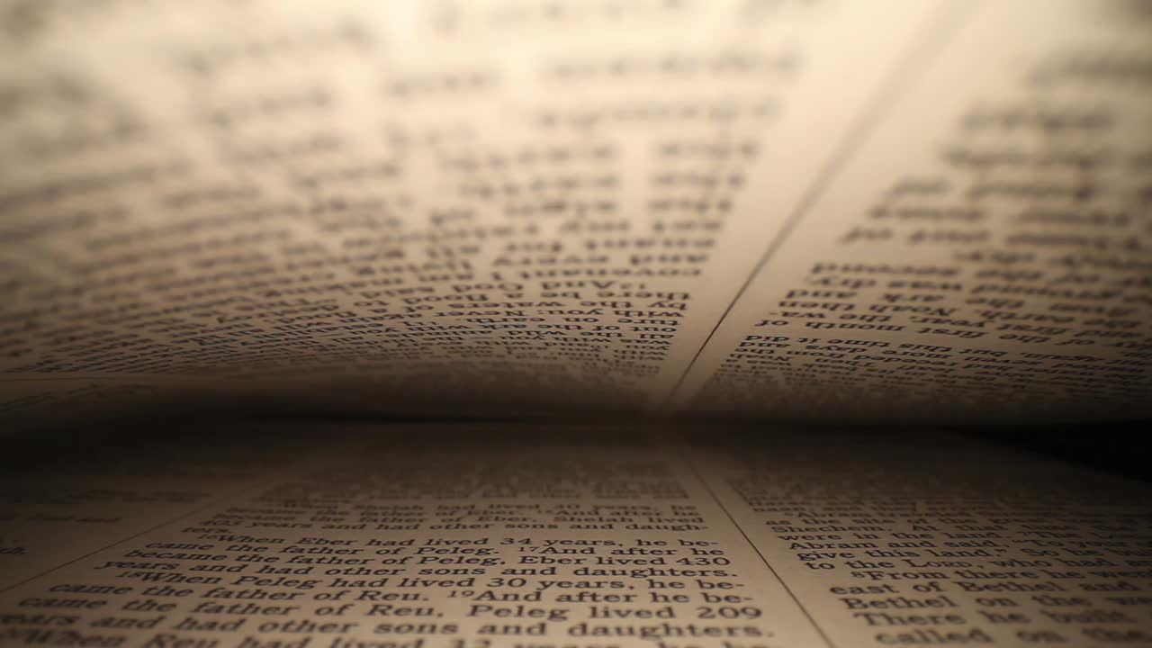 moving laterally through a book right to left, pages on top - bottom of frame as it passes down to the end