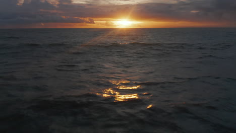 Reveal-of-golden-sunset-above-deep-blue-ocean-with-small-waves.-Beautiful-sunset-at-sea