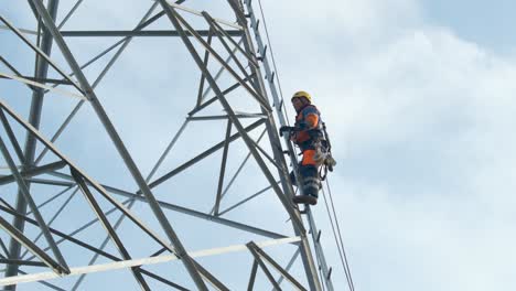 electrician climbs up pylon, secured with a rope