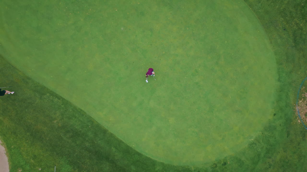 Aerial golfers playing course aiming for nearby flag. Golf players focused game.