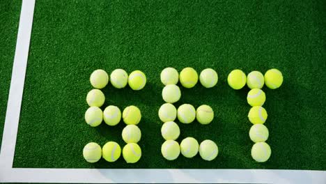 tennis balls forming word set in court 4k