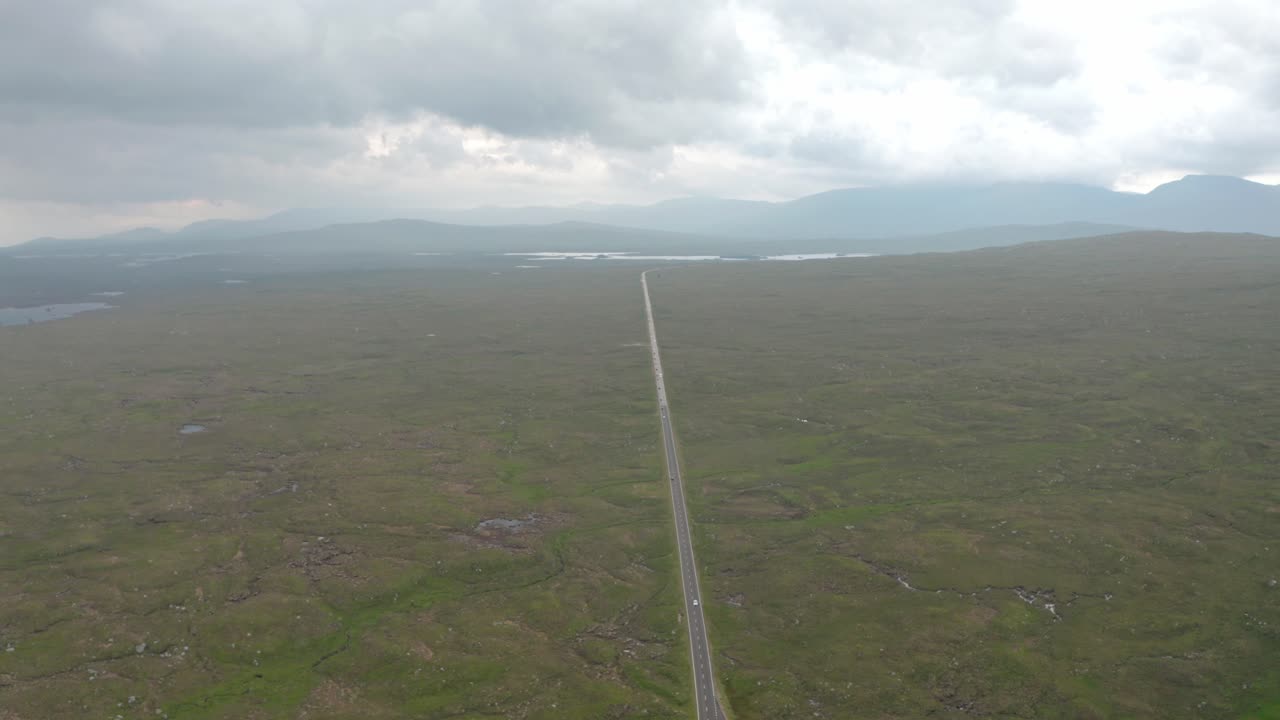 disparo de un dron alto sobre una carretera recta a través de la campiña escocesa
