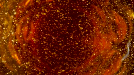 top view of golden liquid with white foam and bursting bubbles top view of golden liquid with white foam and bursting bubbles macro shot of an amber foamy beer cider or lagar carbonated soda or yellow oil beautiful textured beer background for advertising for pub or bar slow motion