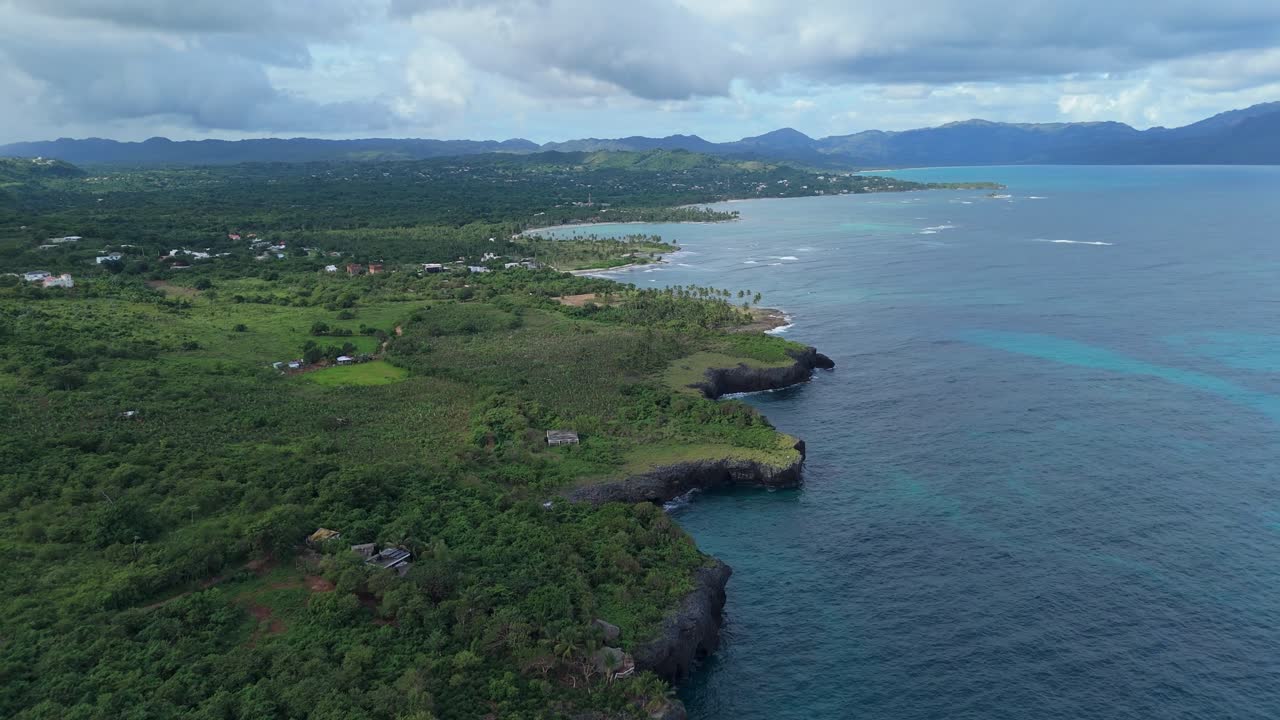 Caribbean landscape, jagged coast and cliffs along tropical sea, Las Galeras, Samana in Dominican Republic. Aerial forward