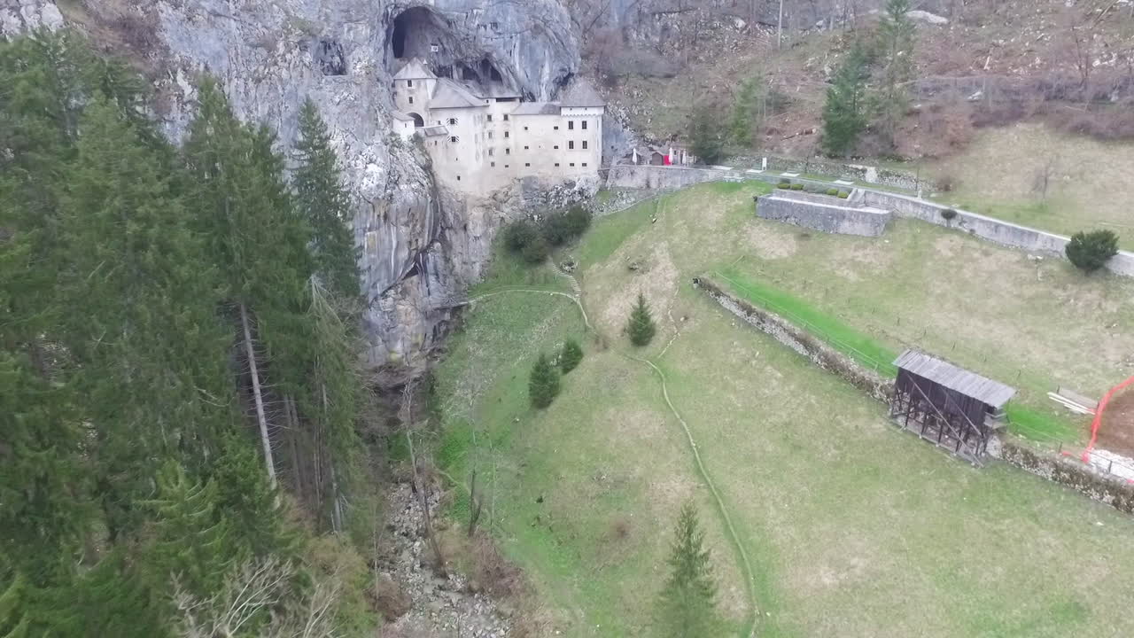 toma de drones del misterioso castillo de predjama, construido en la boca de una cueva en las montañas de eslovenia.