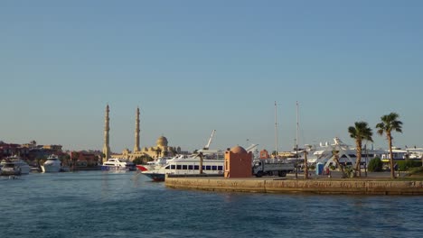 seascape with motor yachts in marina. view of mosque in the background. hurghada, egypt