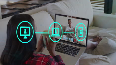 video de interfaz digital e iconos sobre mujer biracial usando computadora portátil