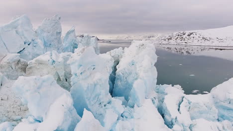 large glacier on sea in frozen hilly landscape, close up drone shot