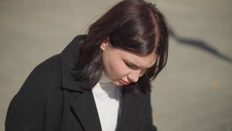 lady seated thoughtfully, illuminated by sunlight, hair swaying in wind, soft light highlighting features, background with an interlocked path