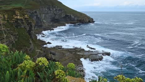 en la isla de isla en cantabria, el mar cantábrico azul se puede ver desde el borde del acantilado rocoso