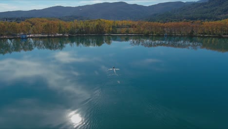 El-Otoño-Del-Lago-Banyoles-Refleja-El-Cielo-Y-El-Sol-Mientras-El-Bote-De-Remos-Se-Mueve-Hacia-La-Orilla.