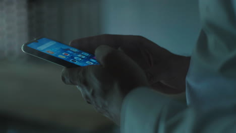 persona que utiliza un teléfono inteligente por la noche