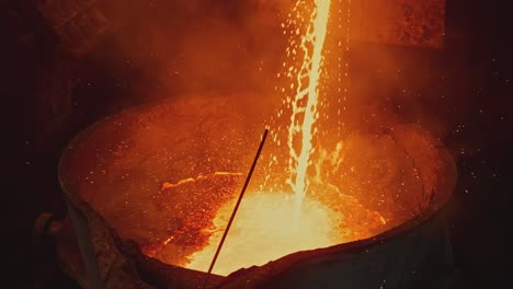 derramamiento de metal fundido en el recipiente de fundición