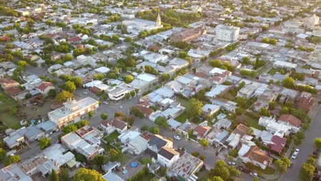 Toma-Aérea-De-Drones-Inclinándose-Hacia-Arriba-De-Un-Pequeño-Pueblo-Durante-La-Puesta-De-Sol,-En-Coronel-Dorrego,-Argentina