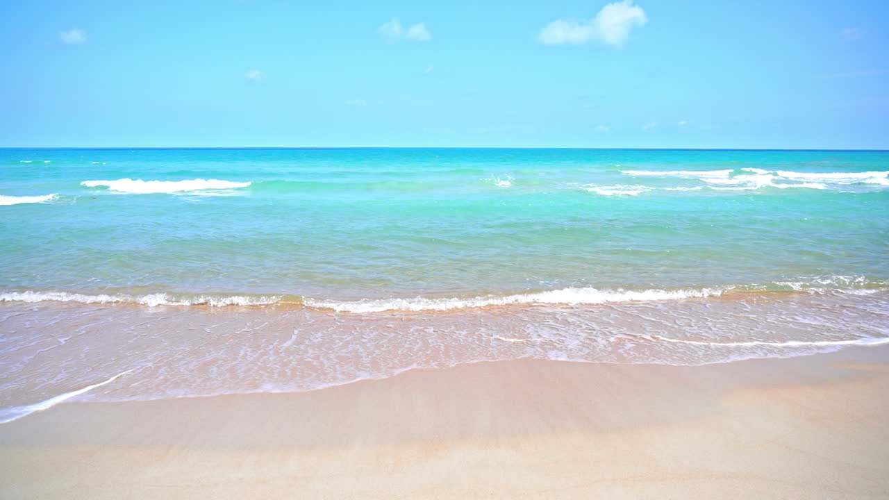 모래와 함께 아름다운 모래 해변과 빛의 날에 칠색 바다의 진정된 파동