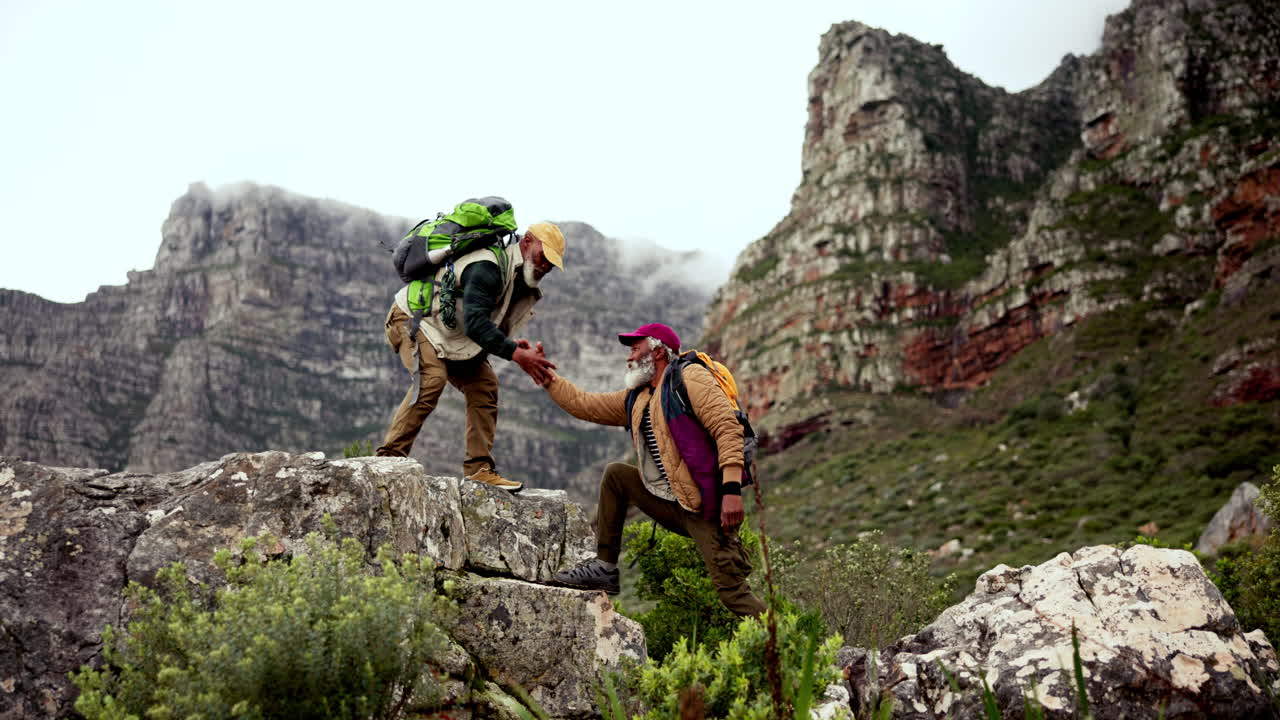 Hikers Helping Each Other on Rocky Mountain Terrain