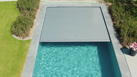 pantalla de la piscina cerrando con hierba verde al lado de la piscina