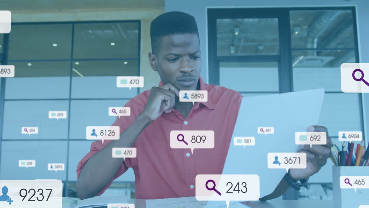 analyst sitting at desk reviewing report, with email, user and search icons for business analytics