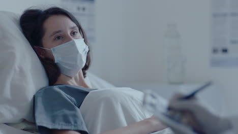 paciente femenina con máscara facial hablando con el médico en la sala del hospital