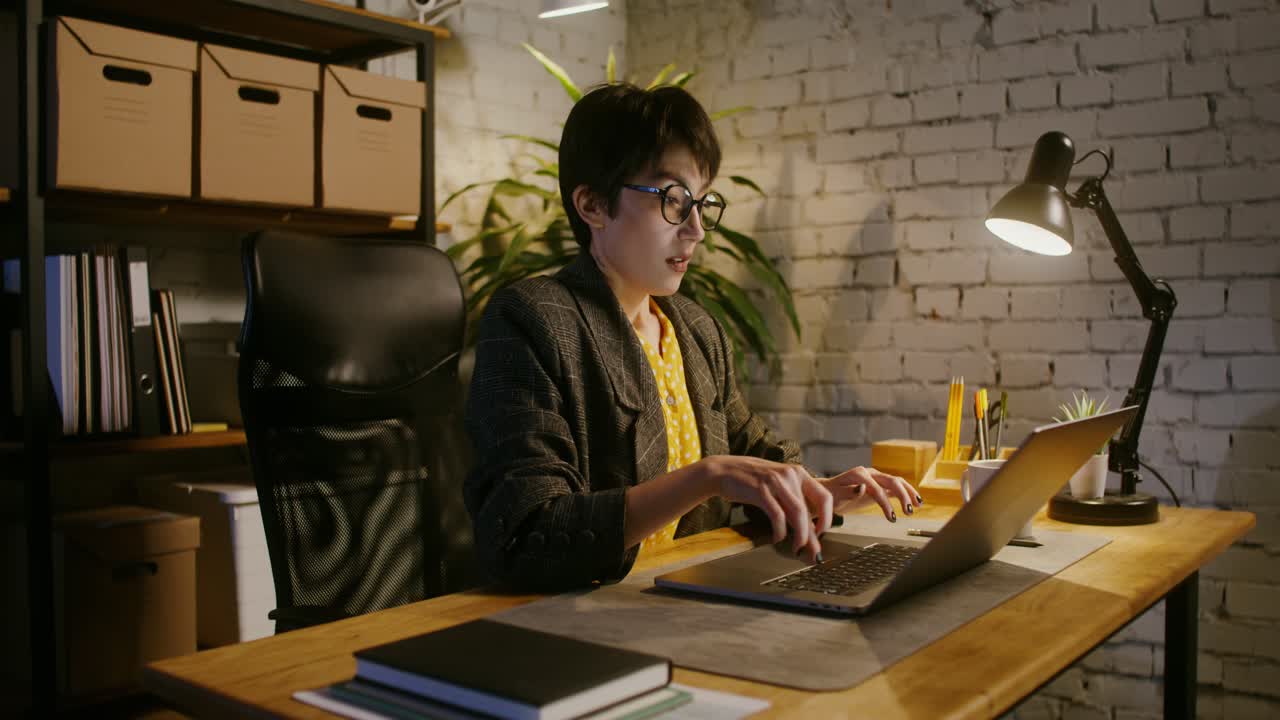 Woman working late at night in home office