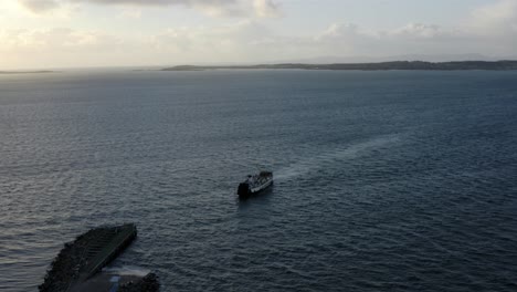 Aéreo---Ferry-Que-Sale-De-La-Isla-De-Gigha,-Kintyre,-Escocia,-Pan-Izquierda