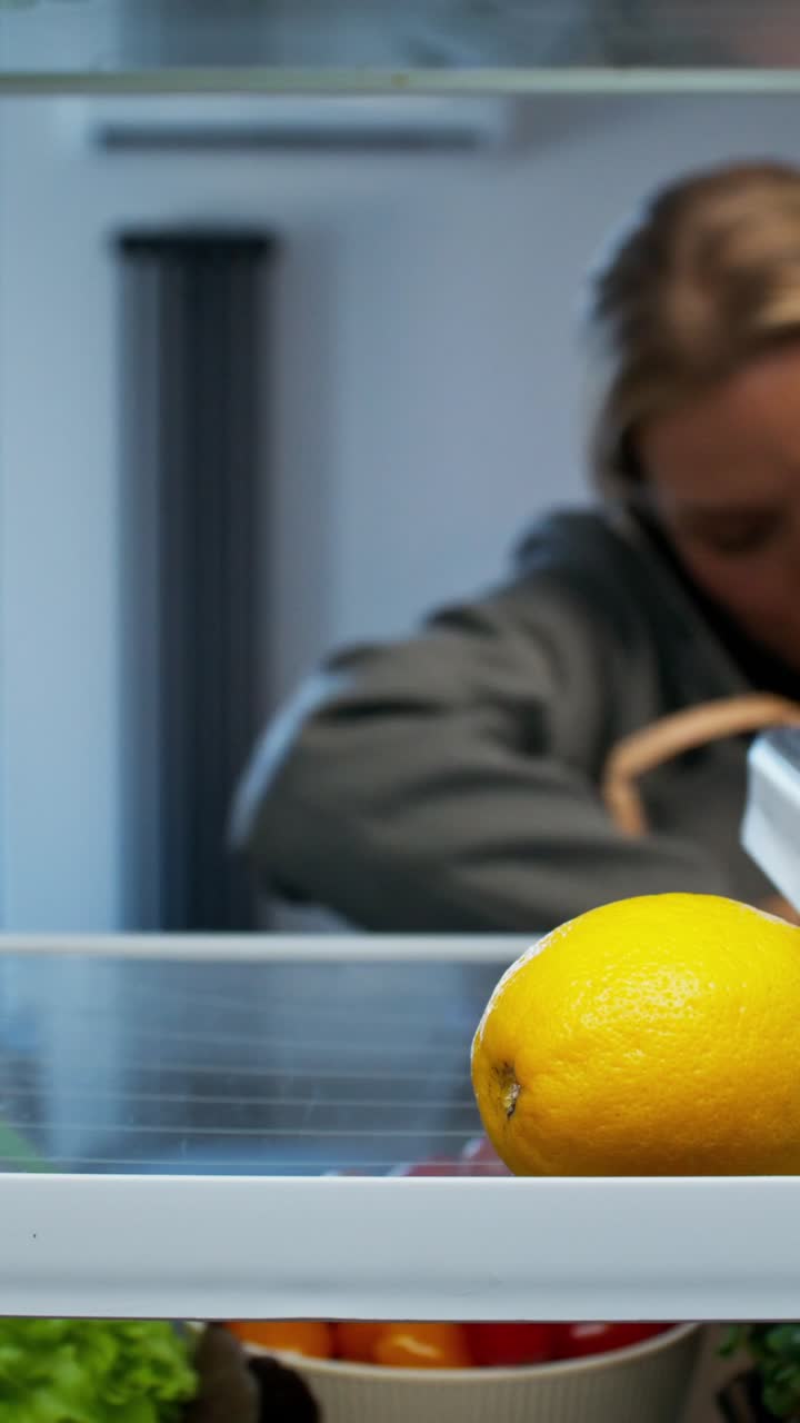 Person Opening Refrigerator to Check Food