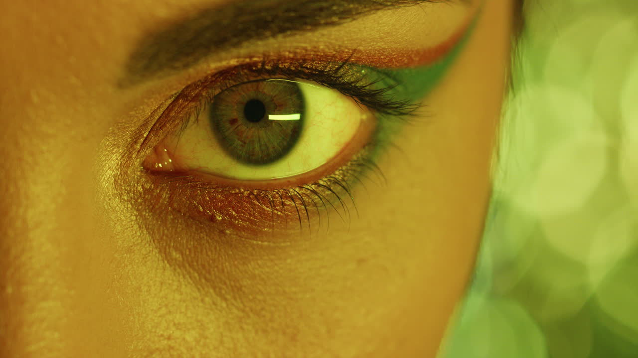 ojo macro de cerca mujer con maquillaje de colores sombra de ojos luz multicolor parpadeando en el concepto del club