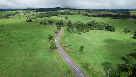 Drohnenaufnahme-über-Einer-Straße-Mit-Einem-In-Der-Ferne-Fahrenden-Wohnmobil-In-Queensland,-Australien