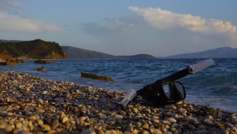 snorkel mask and tube on pebble beach with sea waves background and cloudy sky of the summer