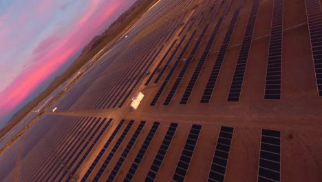 drone fpv volando a través de una granja solar en un desierto durante la hora dorada al amanecer o al anochecer