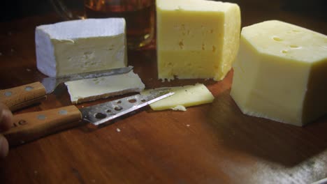 Brie-Und-Gouda-Käse-Werden-In-Nahaufnahme-Auf-Einem-Hölzernen-Schneidebrett-In-Scheiben-Geschnitten