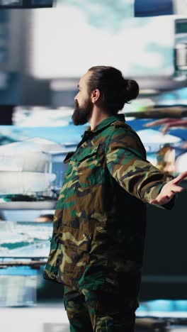 vertical video military soldier satisfied with data collected from surveillance footage