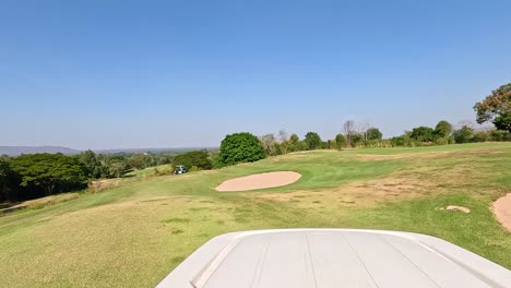 golf cart travels through lush, green landscape