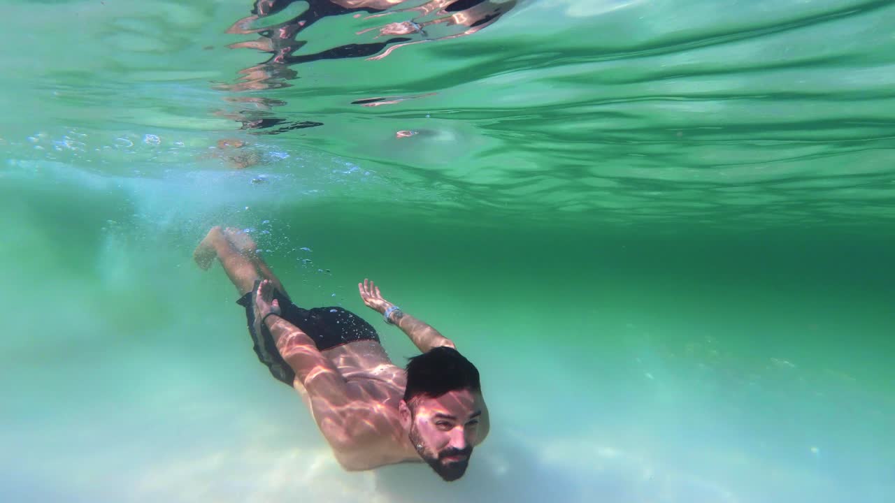 man swimming among the fish happy and excited. day at sea. many fish in the ocean man among fish on a sunny day. 4K