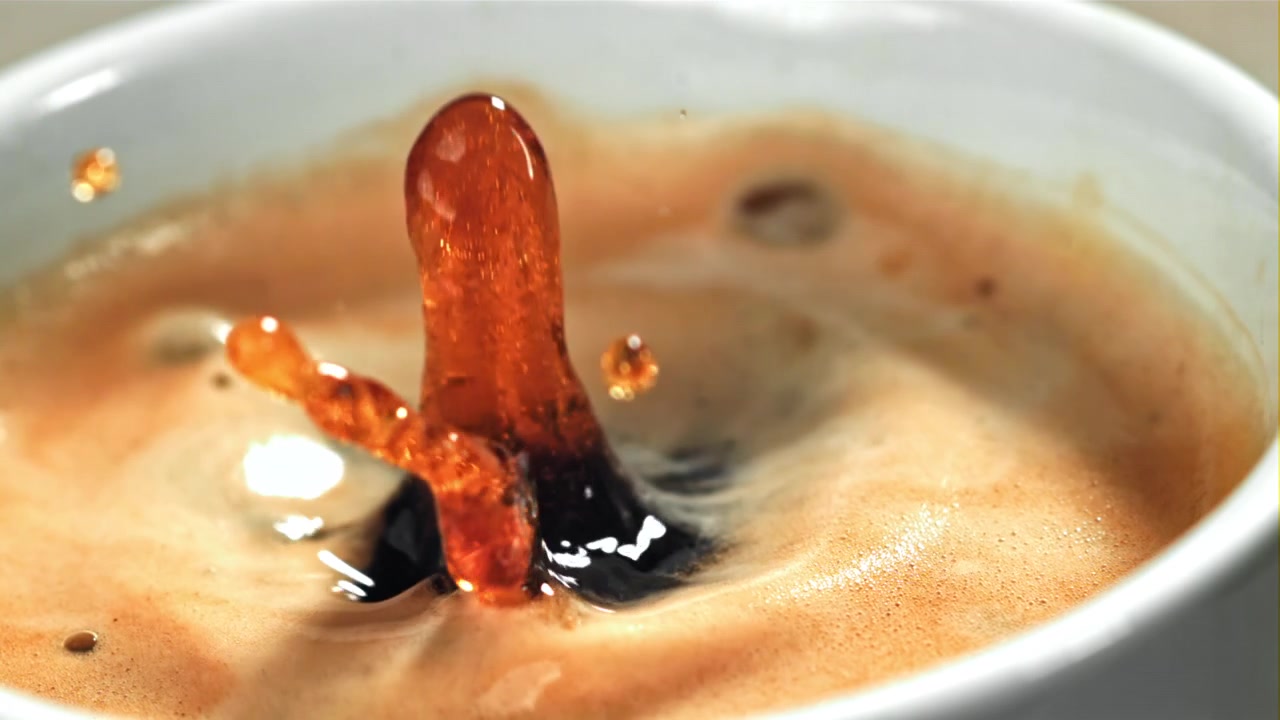 Goccia di caffè che schizza in una tazza di espresso al rallentatore